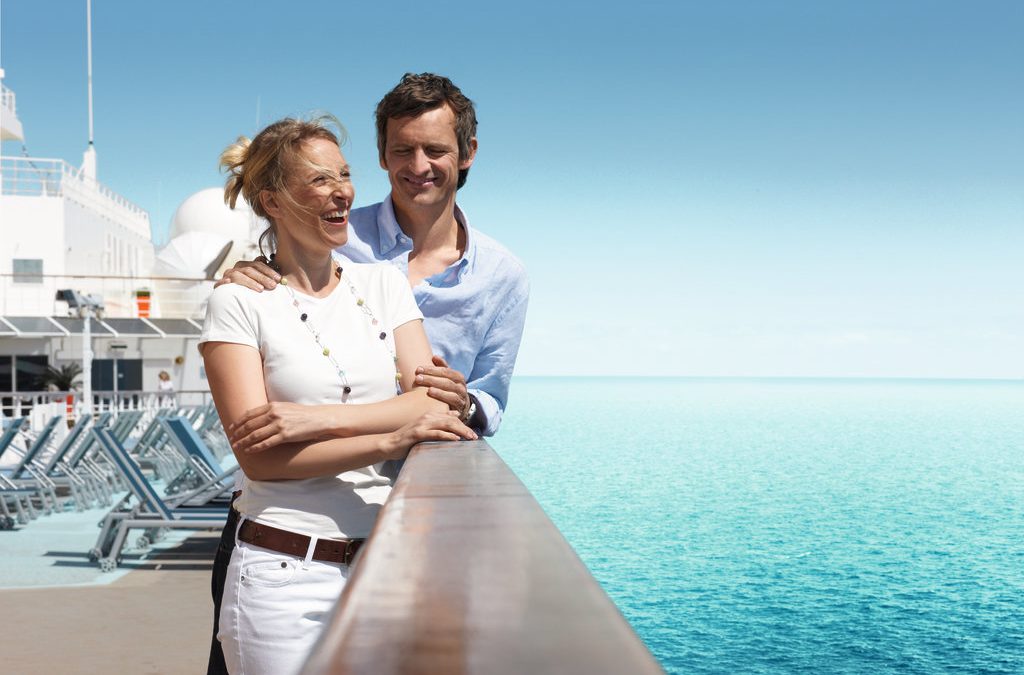 Paar genießt die Aussicht auf dem Deck eines TUI Cruises Schiffs über dem Meer